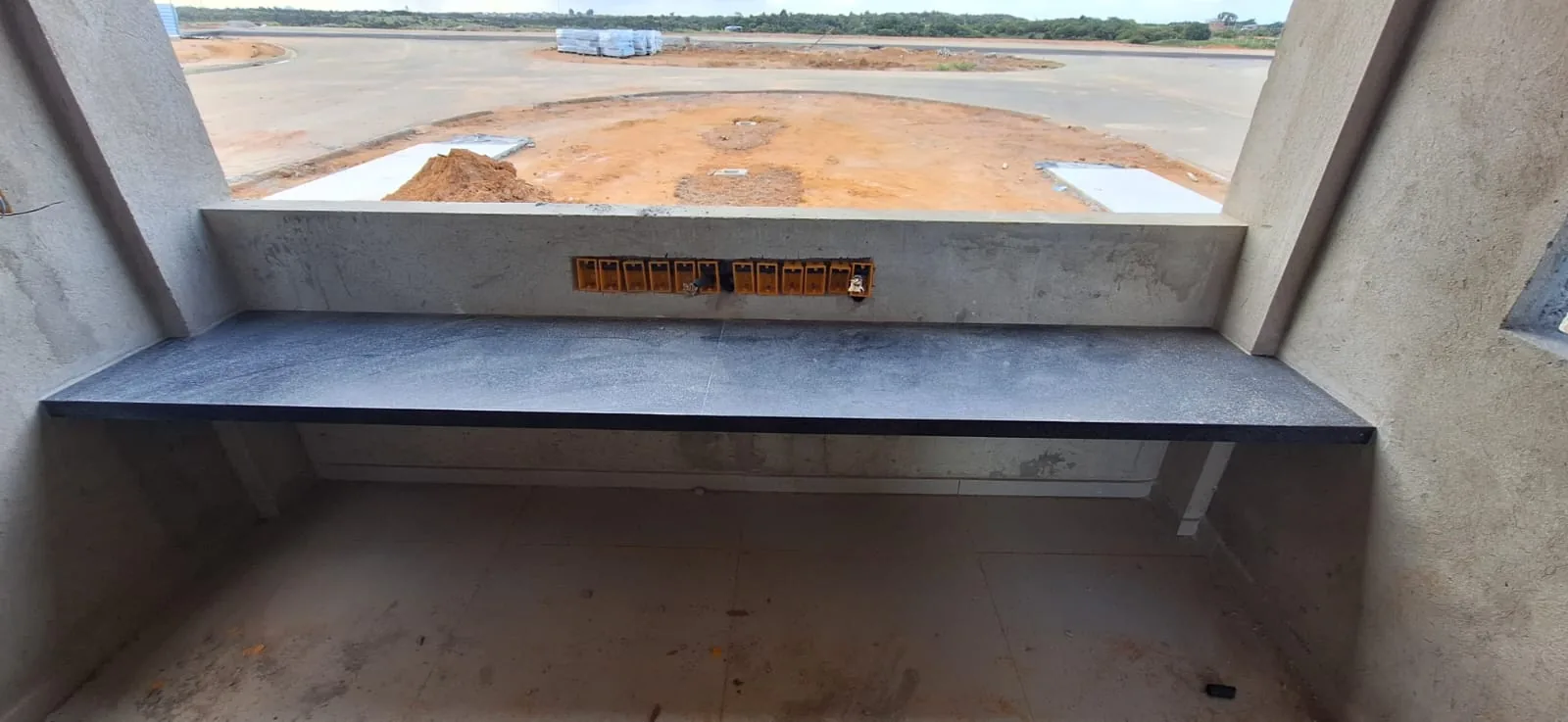 Bancada de granito instalada na guarita, no mesmo acabamento em pedra do prédio administrativo.