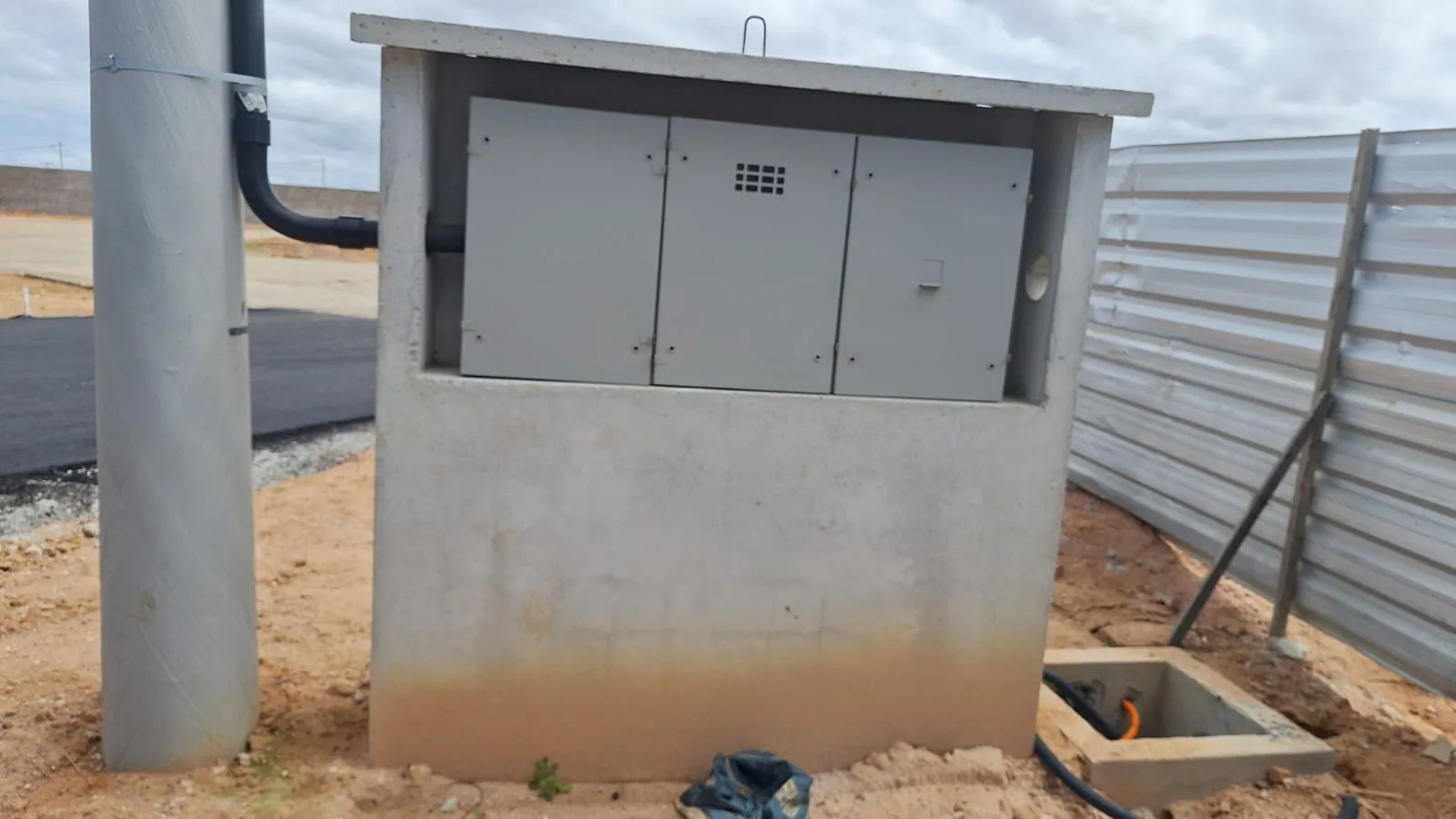A cabine de energia da portaria, assentada sobre a base de concreto.